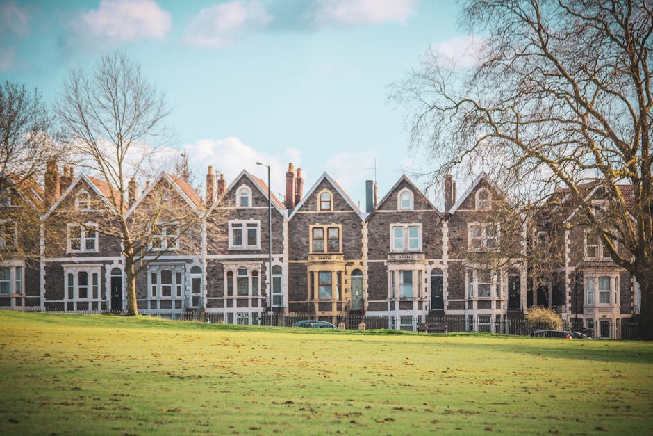 A row of Victorian-style terraced houses with brick facades, white window frames, and decorative bay windows along a residential street in Stockwell Park Estate. The pavement is clean and well-maintai